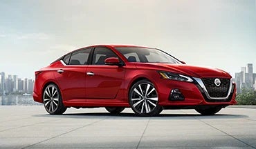 2023 Nissan Altima in red with city in background illustrating last year's 2022 model in Coughlin Nissan of Heath in Heath OH