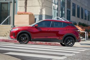 Red 2022 Nissan Kicks driving in the city.