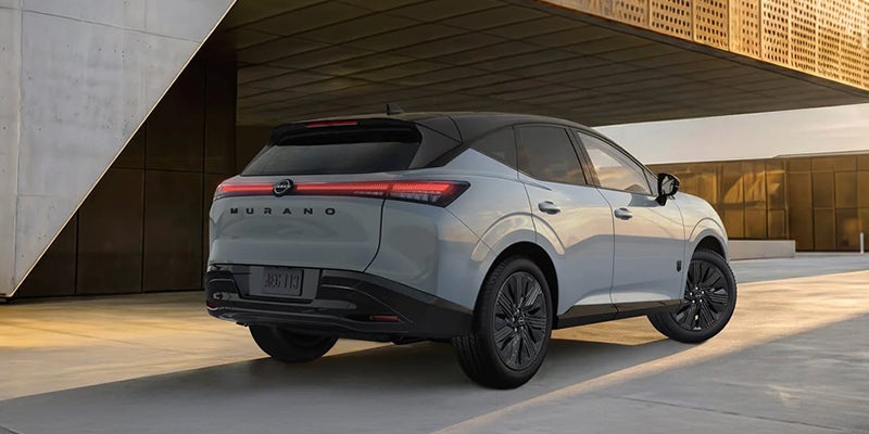 Gray Nissan Murano parked outside a modern building.